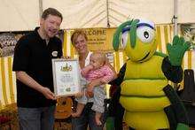 Chairman of the KM Charity Team, Simon Dolby, presenting a thank you certificate to Bel's human resources manager Lyndsey Moore with her daughter Joanna and the charity's bug character