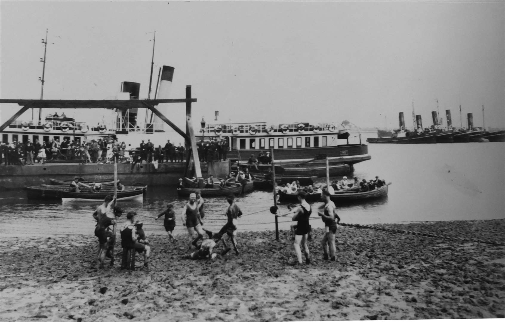 The mudlarks of Gravesend in a wrestling match on the beach alongside the pier in 1925