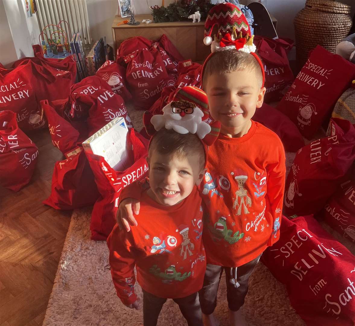 Santa's elves Ted Merrall, five, and his brother Kit, three, have been helping their mum Cia and the Upchurch Support Network to deliver 100 Christmas stockings to children in need