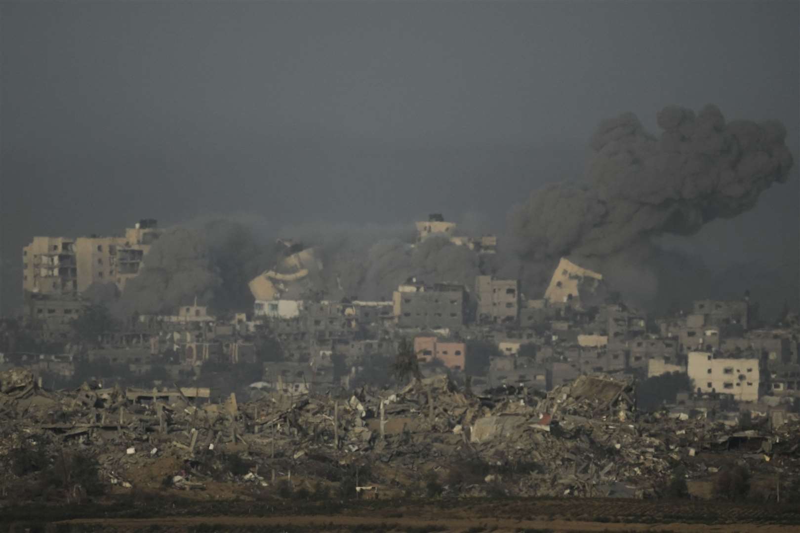 A building collapses following an Israeli air strike in the Gaza Strip, as seen from southern Israel (Leo Correa/AP)