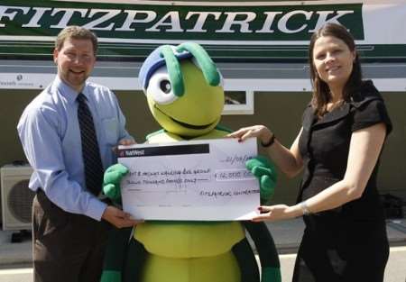 Sally Butler of Fitzpatrick presents Buster the Bug and Simon Dolby of the KM Walk to School team with a sponsorship cheque to support the Walk on Wednesday and Walking Bug services for the coming year.