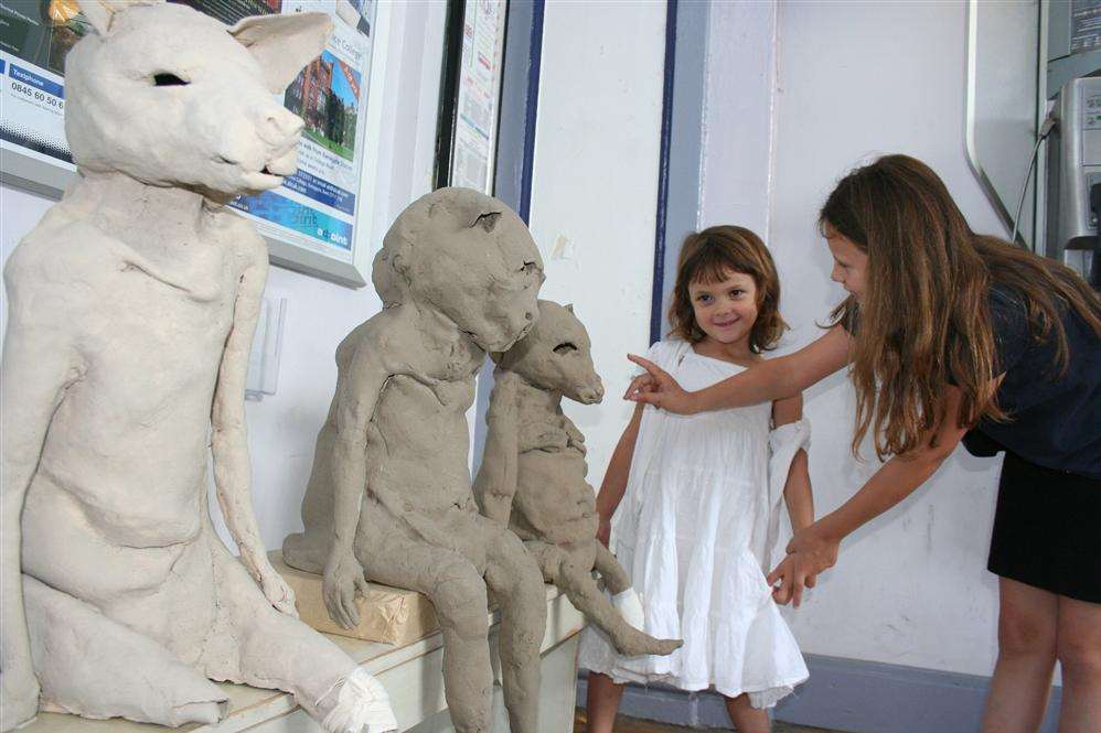 Sisters Leila-Pearl Fountas, five, and Evie Fountas, eight, from Canterbury study melancholy clay animal figures in The Waiting Room