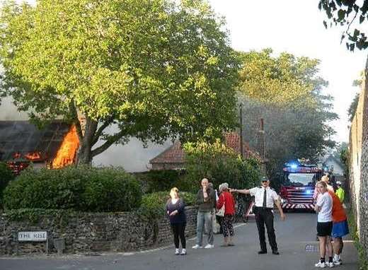 Community warden Malcolm Wells directing the traffic in Upper Street while the barn is alight