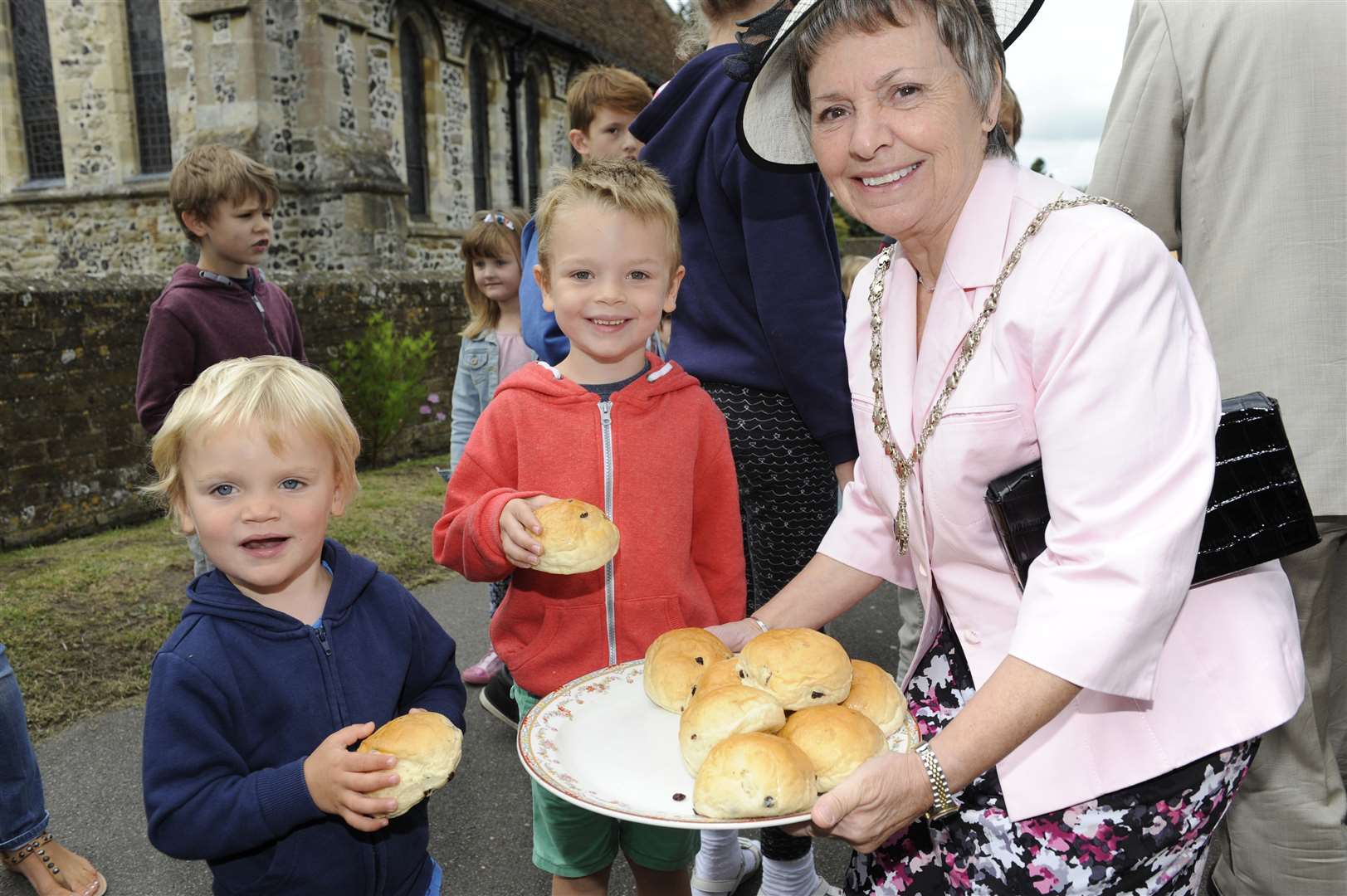Mayoress Sue Graeme hands outs buns to Sac Lovett aged two and Luca Lovett aged four