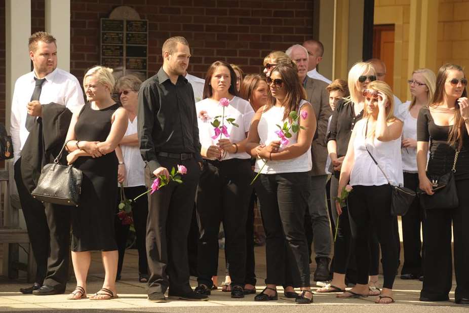 Mourners clutch roses at the funeral of Jade Glen and Dolly May
