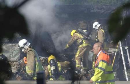 Fire crews digging through the cargo in an attempt to put the fire completely out. Picture: PAUL DENNIS