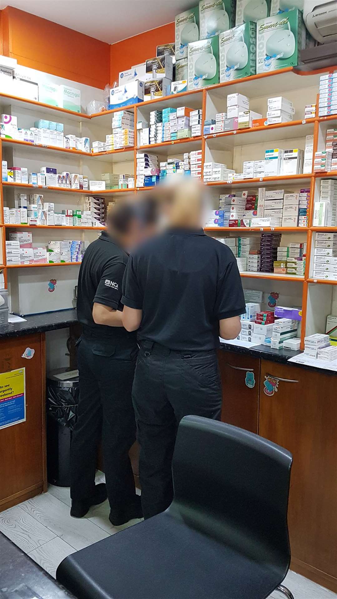 NCA officers search a pharmacy in south London after arresting a 46-year-old on suspicion of illegally selling Covid-19 tests (NCA handout/PA)