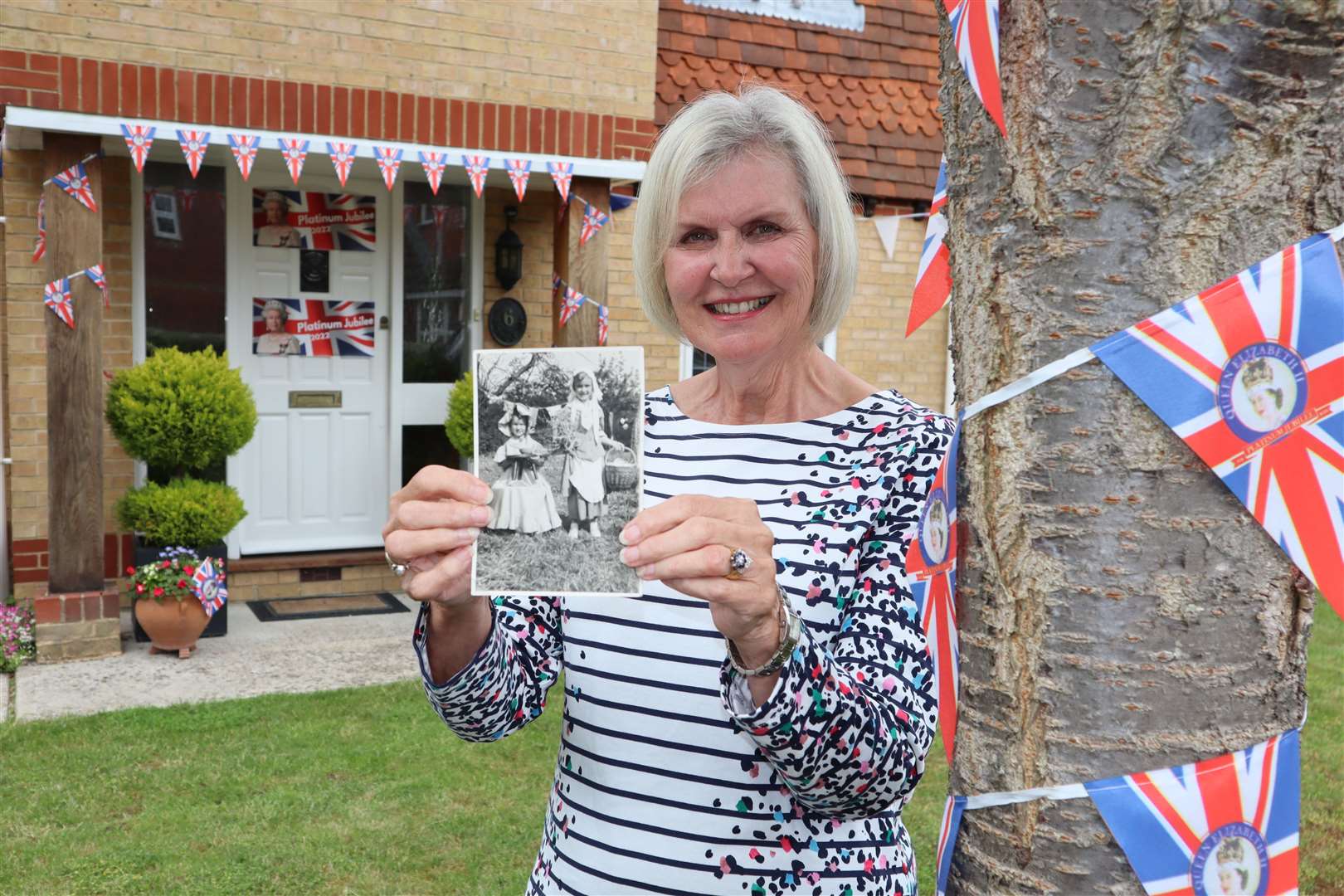 Heather Littlewood, 72, of Ladyfields Close, Sittingbourne, holding a photo of her and her sister Pauline Day when they were at a fete to celebrate the Queen's coronation in 1953