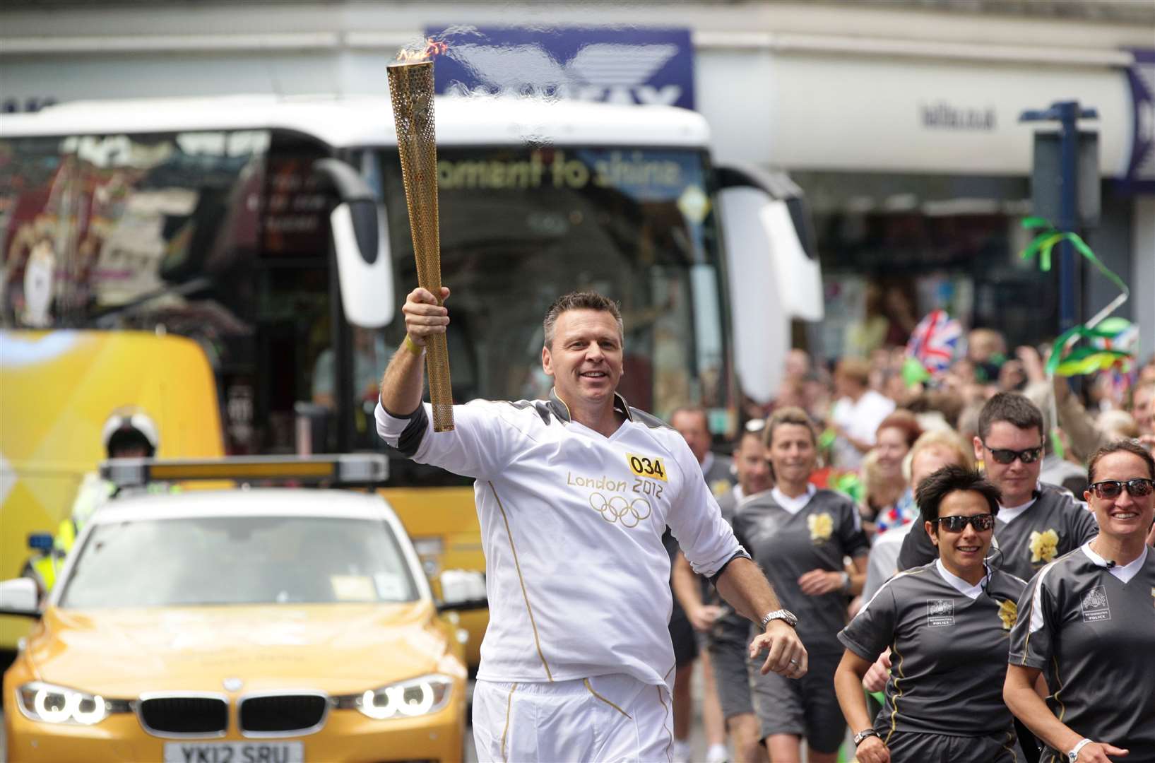 Former Olympian Steve Backley carries the flame at Ramsgate. Pic: Locog
