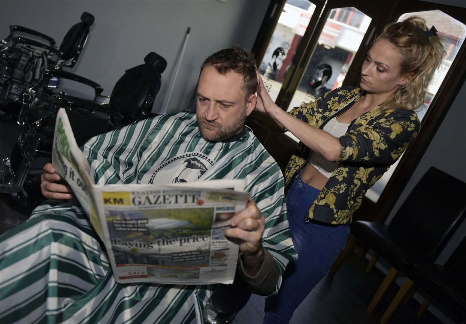 Customer Richard Gould from Littlebourne gets some essential reading in whilst Billie Jean cuts his hair