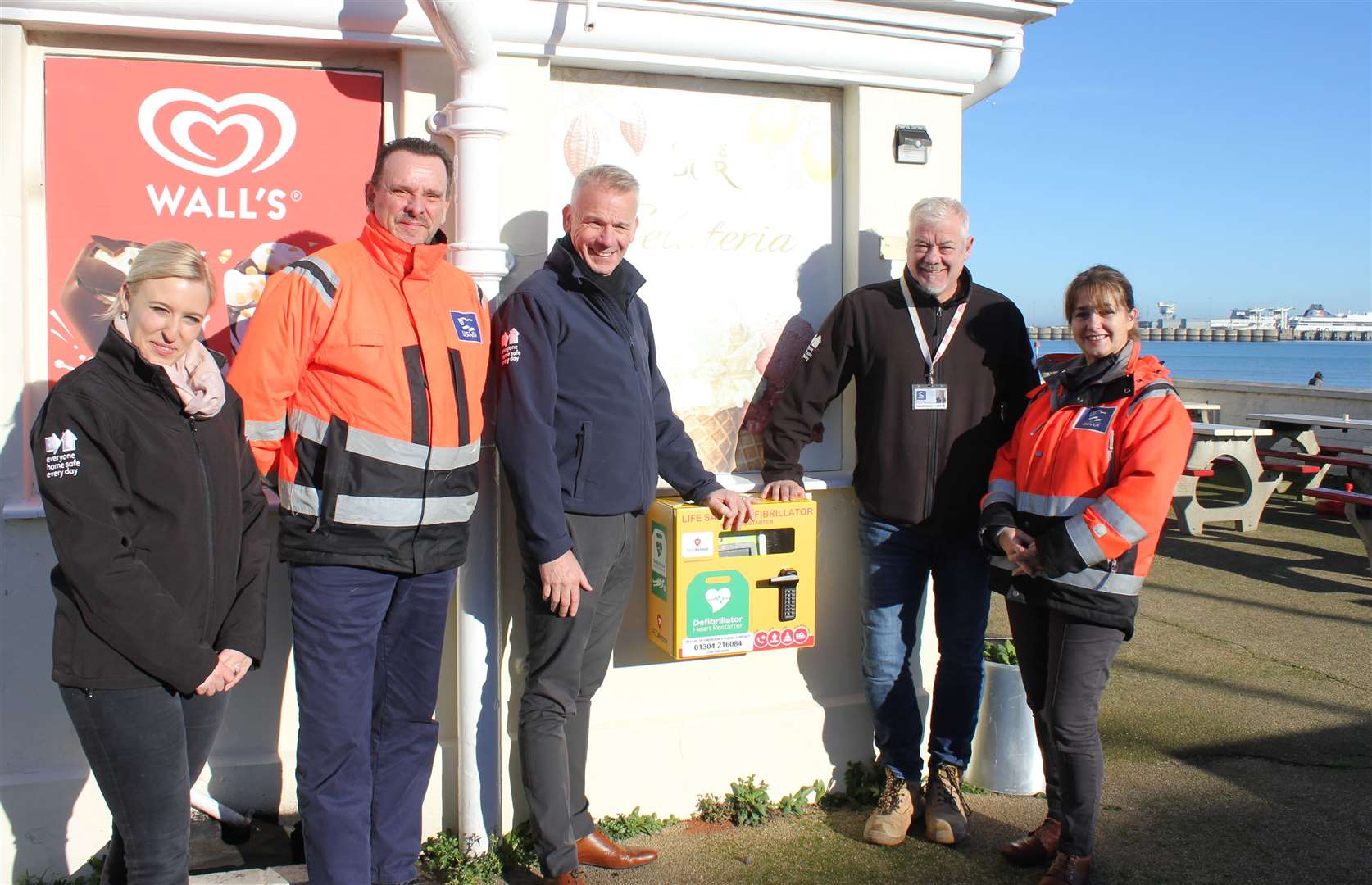 The new defibrillator at the ice cream kiosk. Those shown are Walker Construction personnel, including managing director Phil Webb, and port staff. Picture: Port of Dover