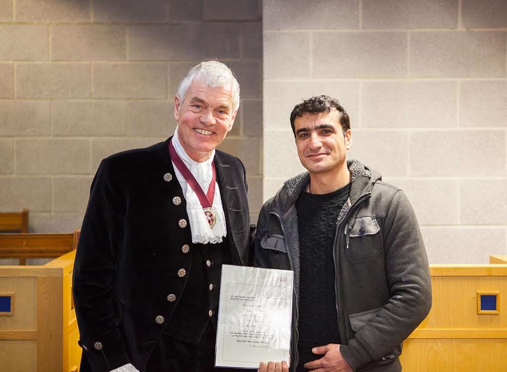 Ali Samivand receives his award from High Sheriff William Alexander