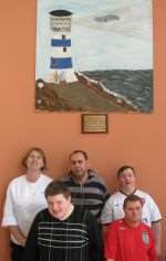 Nina Clancy from the Lighthouse Cafe is presented with the mural by members of the Crawford Centre