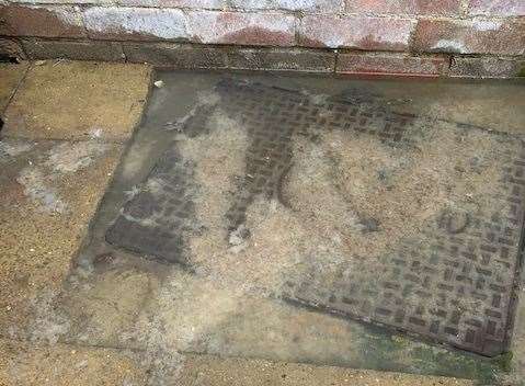 The overflowing manhole cover at the family's home