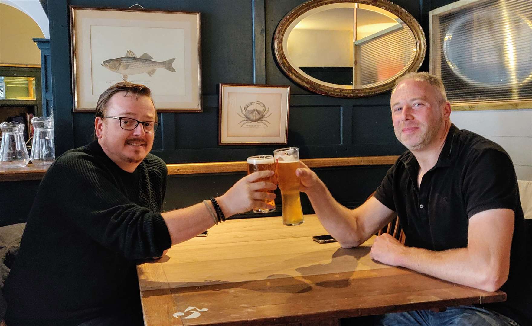 Friends Mike Hedges, left, and Matt Lane, raise a glass as pubs across the country emerged from lockdown
