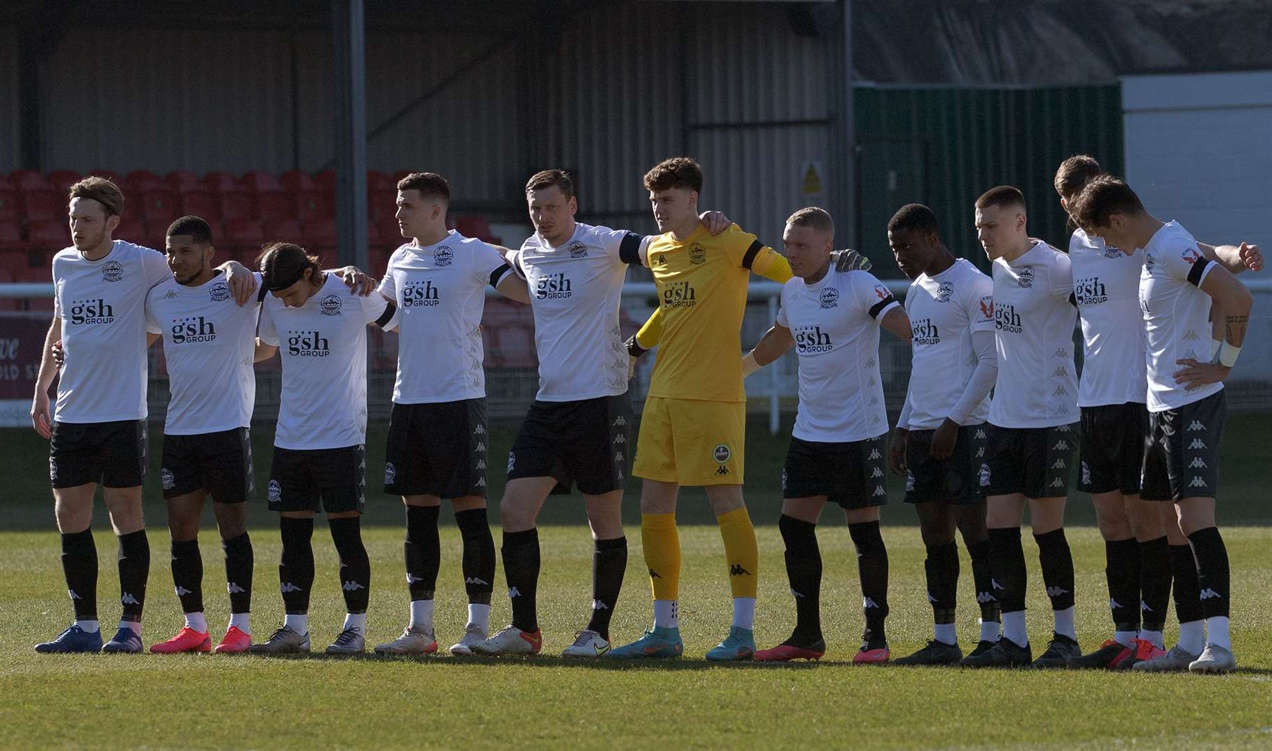 Dover's players stand together in a huddle for the one-minute silence in memory of Mr Harris before the game. Picture: Stuart Brock
