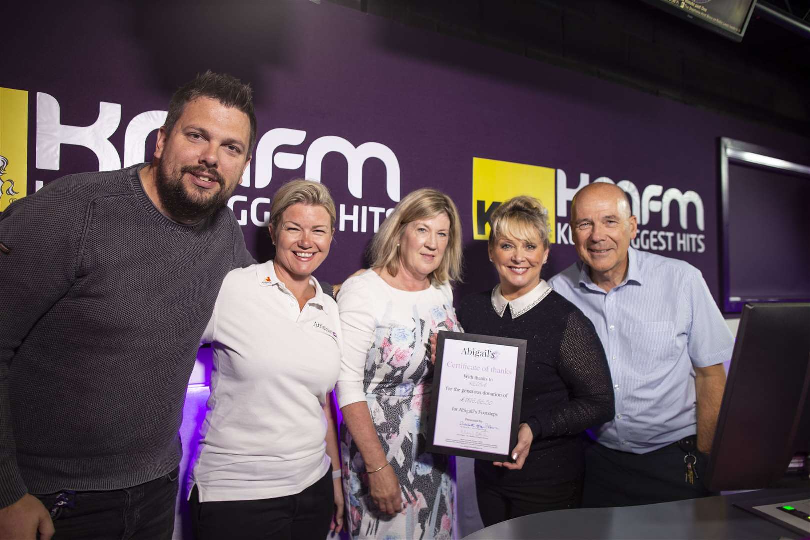 Cheryl Baker in the kmfm studios to present a certificate to the KM team for money raised for the charity Abigail's Footsteps