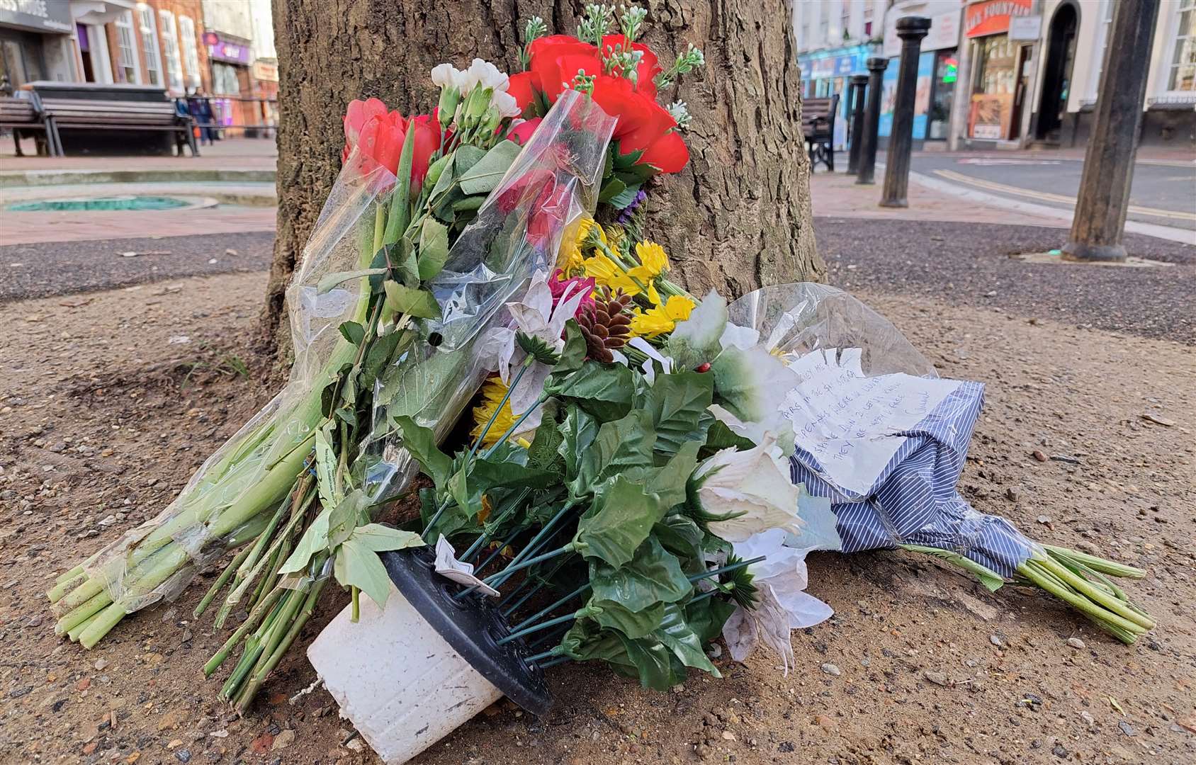 Floral tributes have been left under a tree in the Lower High Street