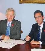Sandy Bruce-Lockhart, left, signs the broadband agreement with Pierre Danon
