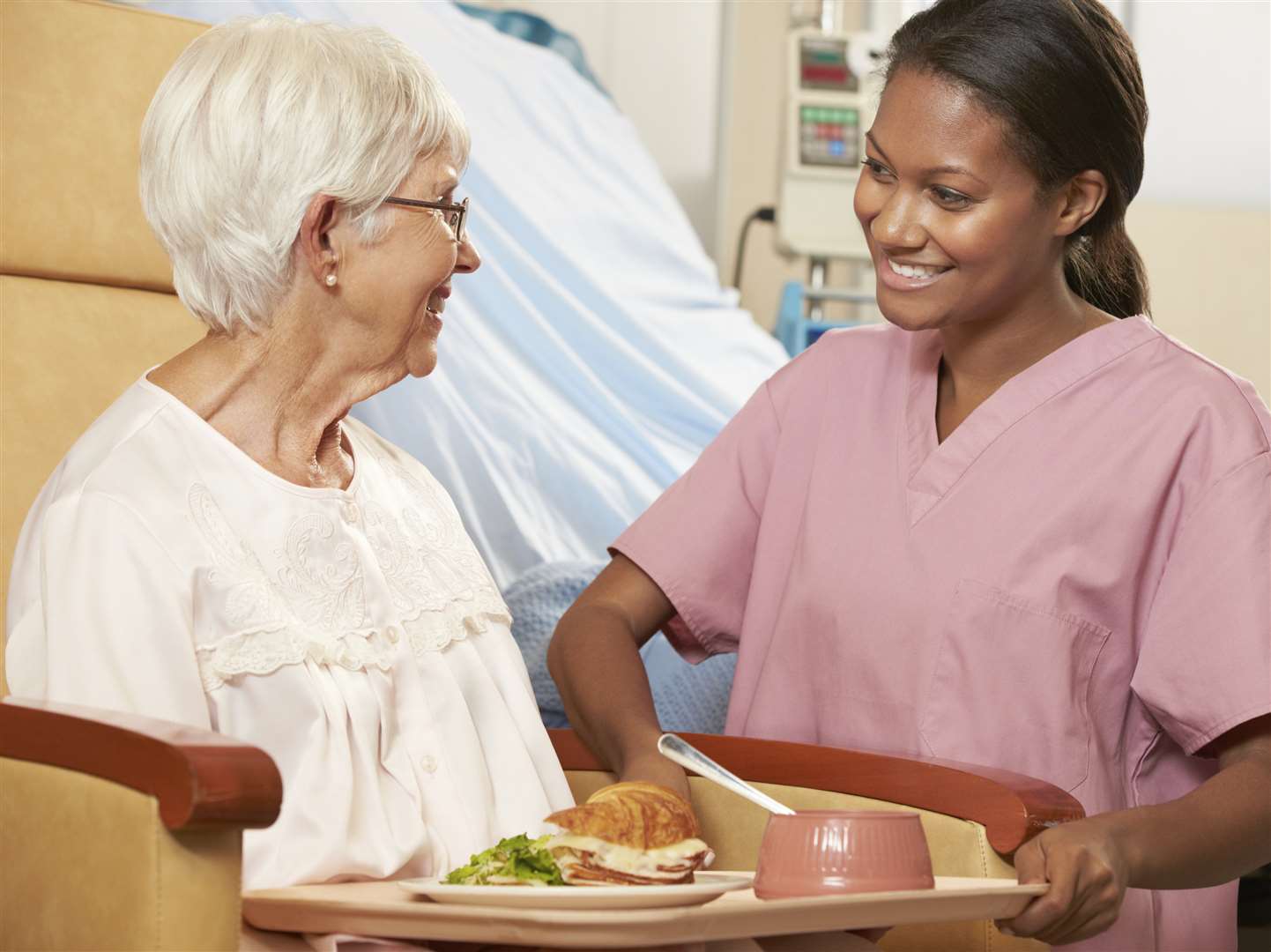 Nurse serving a meal to a patient. Stock picture