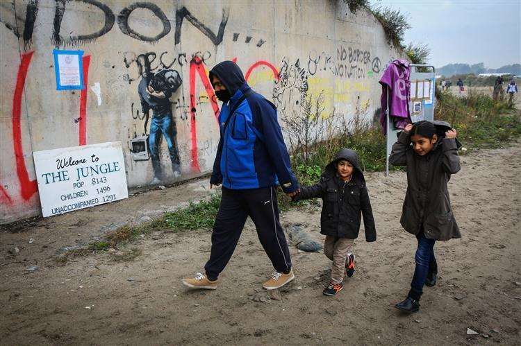 A family in the Jungle in Calais in 2016. Picture: SWNS (2200572)