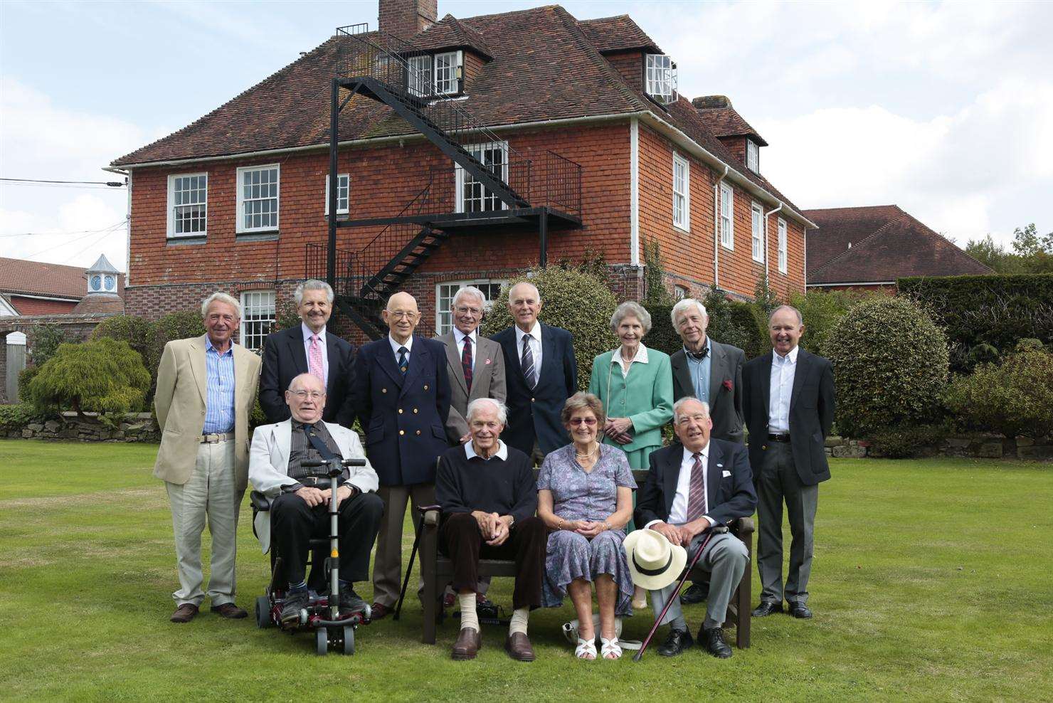 Former pupils on the lawn where the original school photo was taken 75 years ago