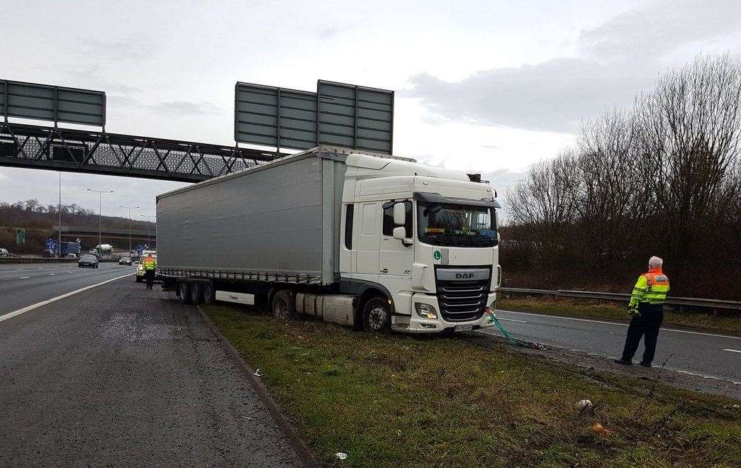 A lorry stuck on a grass verge at J1 of the M2 – the driver attempted to change lanes, correcting a mistake he made when confused by his sat-nav. Picture: Kent Police