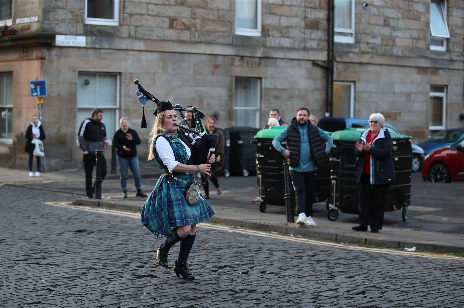 Piper Louise Marshall performs in Leith, Edinburgh, during Thursday’s nationwide clap for carers (Jane Barlow/PA)