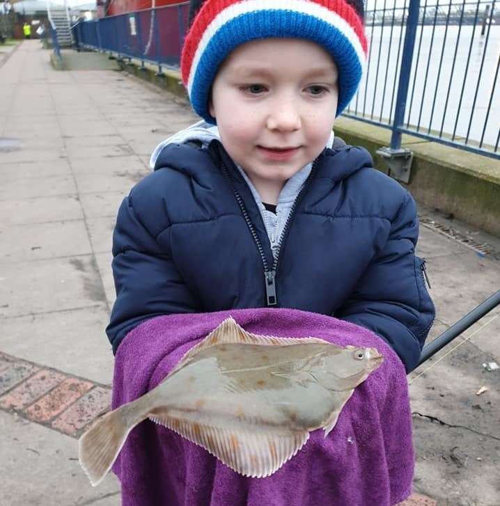 A young angler shows off his catch