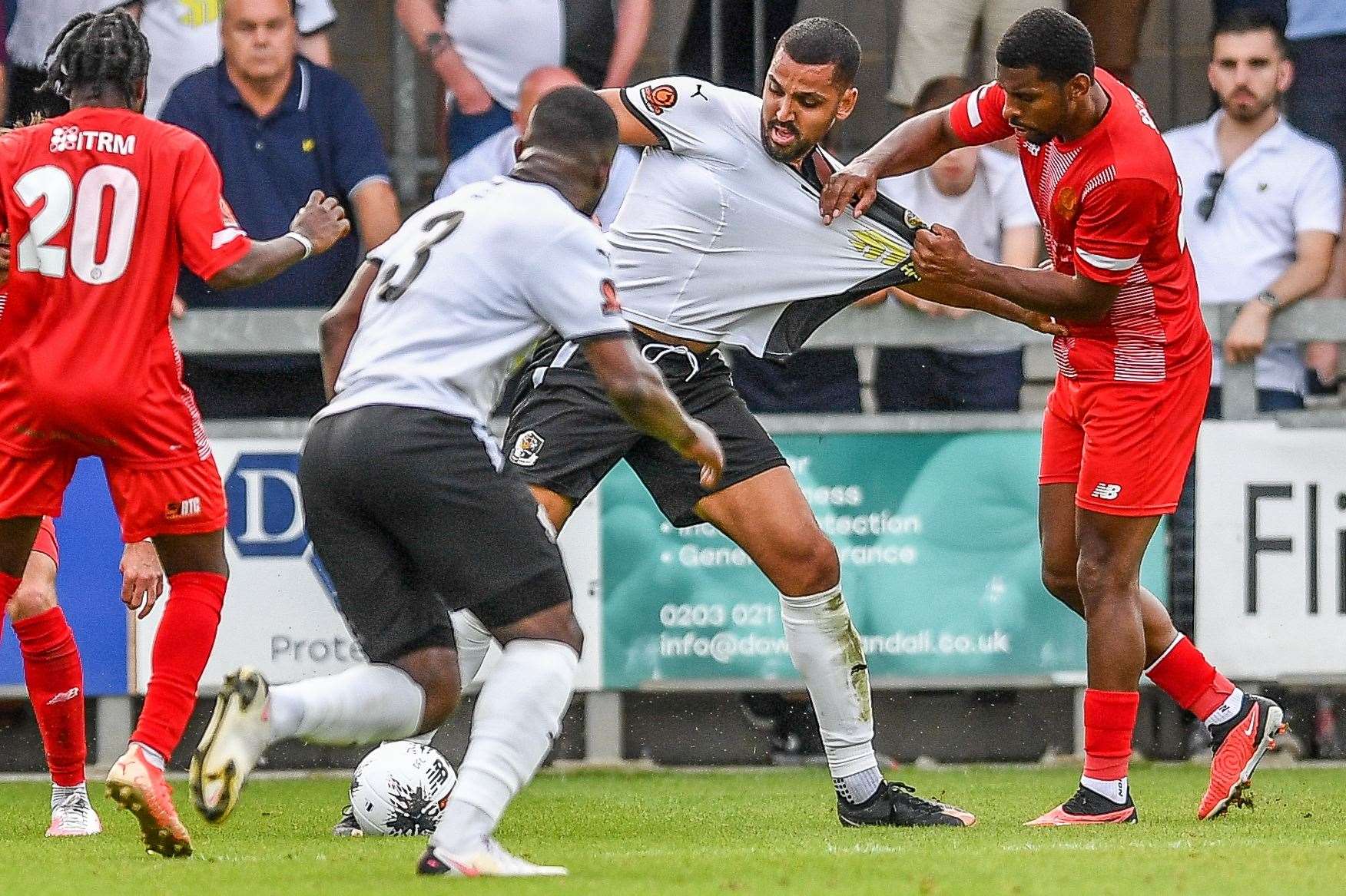 A Welling player gets a fistful of Dartford striker Lewis Manor's shirt as defender Sam Oduadu offers support. Picture: Dave Budden