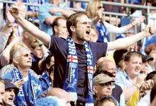 A fan leads the singing in the Gillingham end