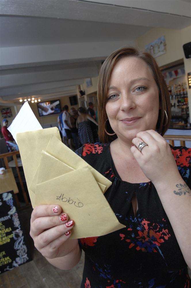 Beach Pub Landlady Caroline Ashworth reads one of the cheeky ideas for her tattoo