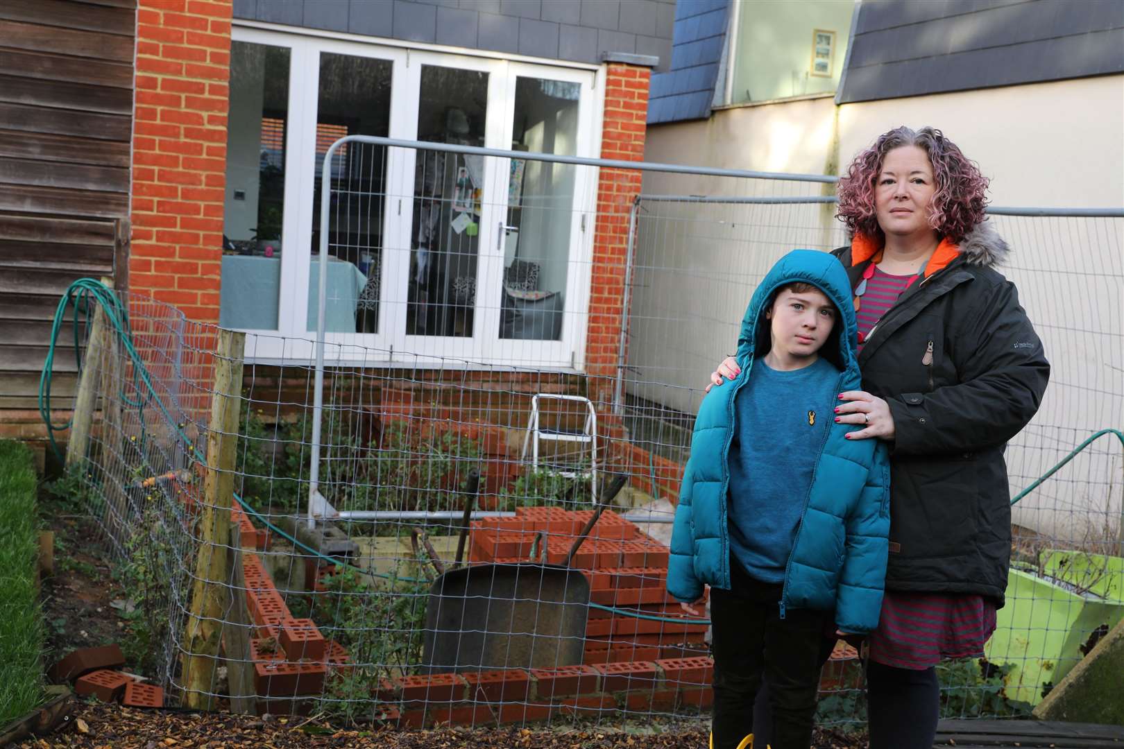 Shelley Weeks and son Olly Weeks, 8, next to incomplete building work Picture: Andy Jones