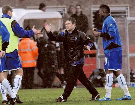 Andy Hessenthaler celebrates with injured captain Andy Frampton and Dennis Oli