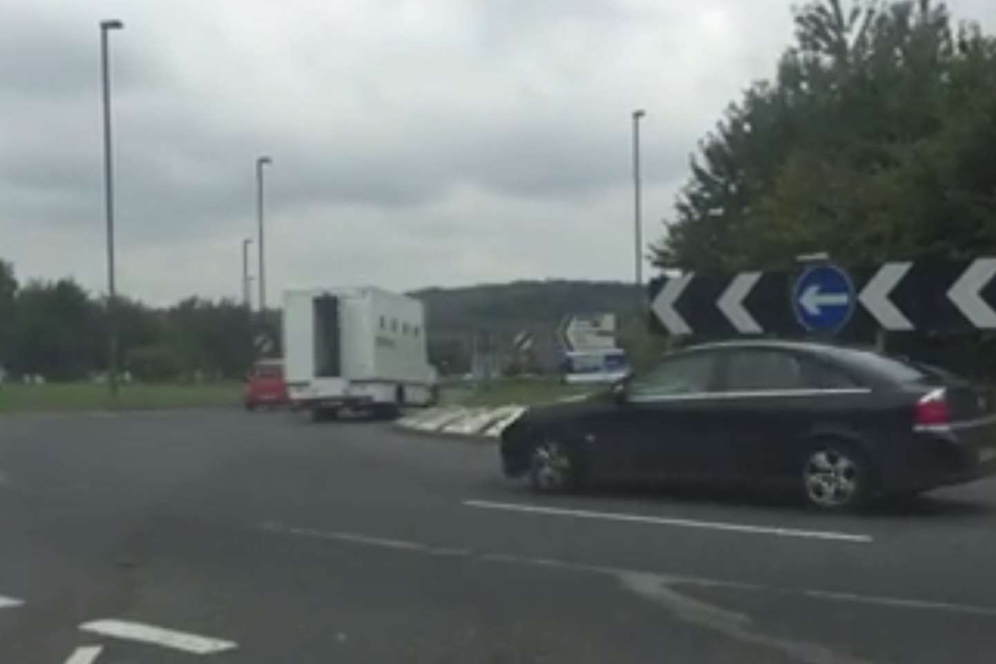 The door flaps open as the prison van is driven around the roundabout