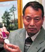 Former Gurkha Madan Gurung holding his Long Service and Good Conduct Medal