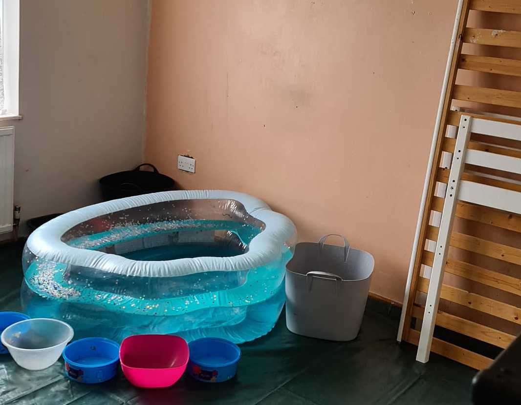 Miss Johnson has had to put a paddling pool, bowls, a bucket and tarpaulin under the roof to catch rainwater. Picture: Kelly Johnson