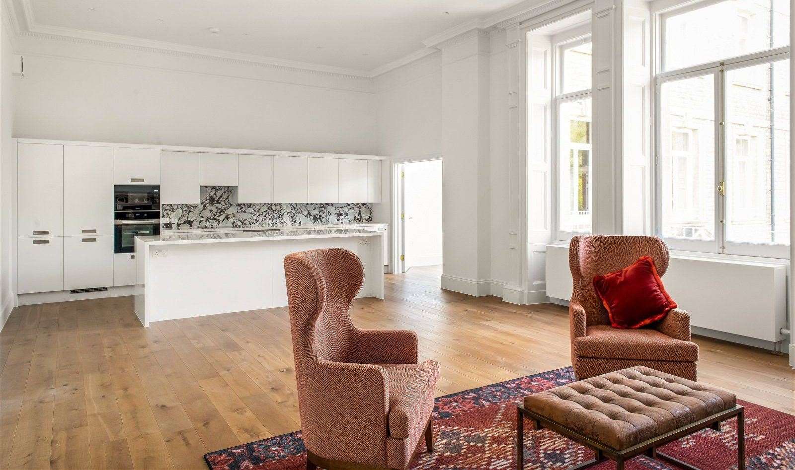 The pricey apartment has a spacious kitchen and living room area with marble fireplace. Picture: Maison