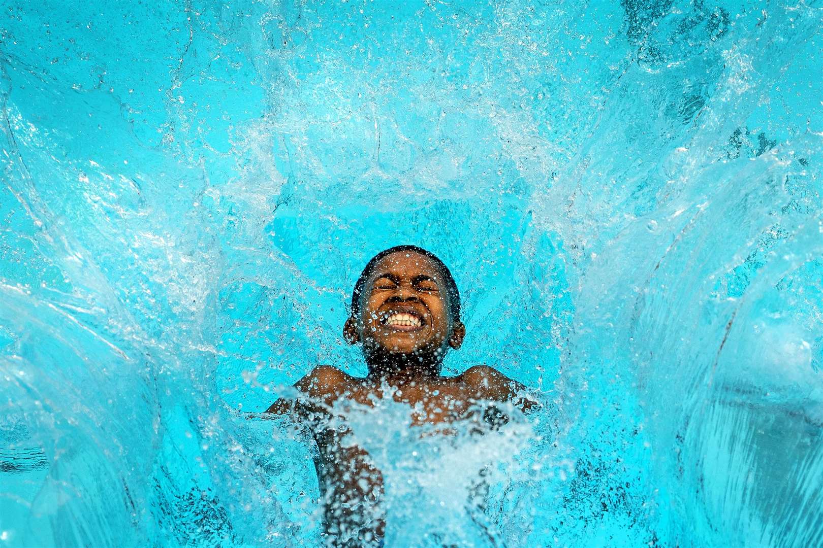 Reuben Hurst, 13, makes a splash as he cools down (Victoria Jones/PA)