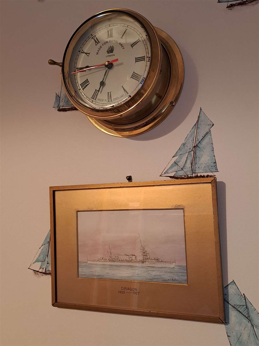 The non-functioning porthole clock above a painting of HMS Dragon in my son's nautical themed bedroom