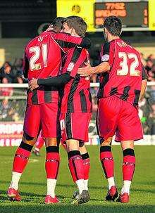 Gillingham came from behind to earn a 1-1 draw at Burton Albion in League 2 on Saturday. The Gills players celebrate Cody McDonald's late equaliser.