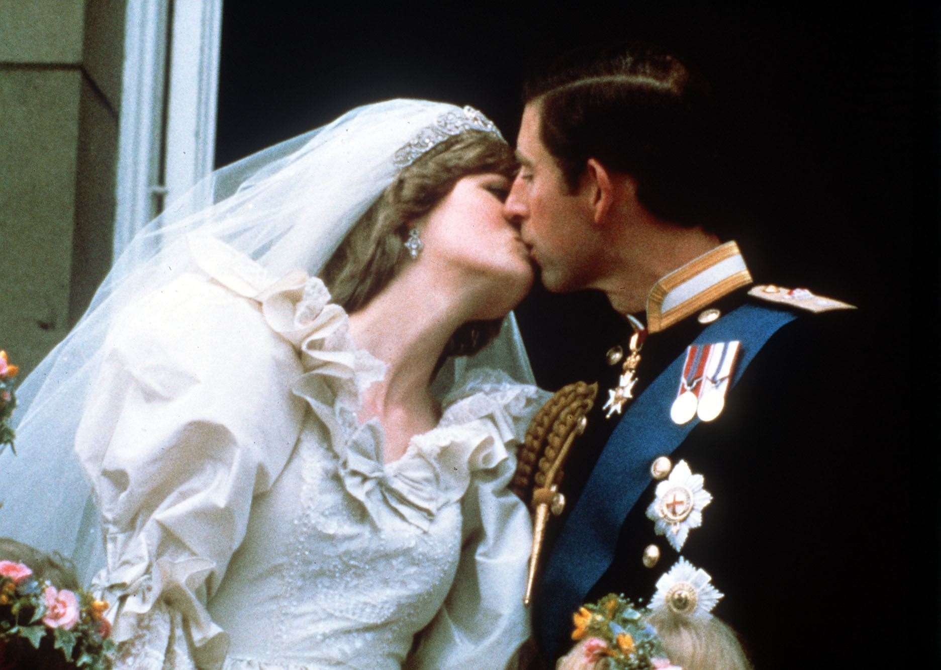 The Prince and Princess of Wales kiss on the balcony of Buckingham Palace after their wedding (PA)