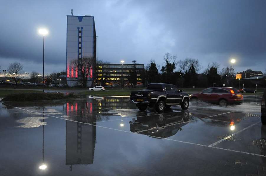 Storm clouds gather over International House and a flooded Stour Centre car park in Ashford. Picture: Gary Browne