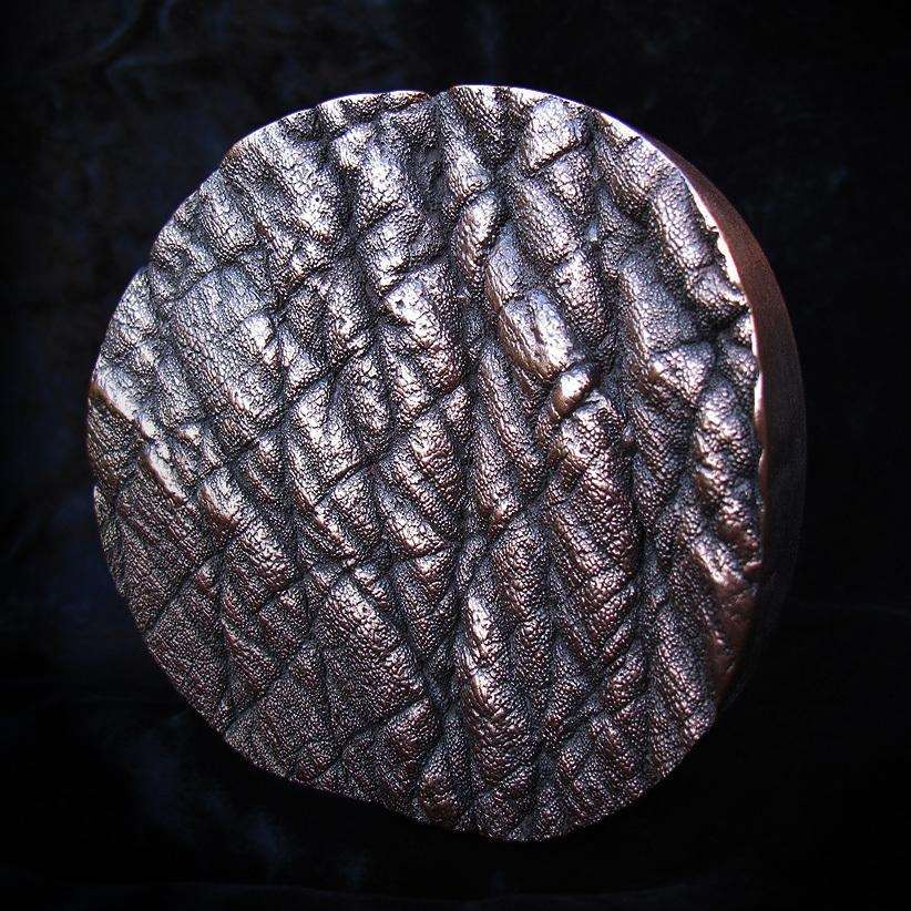 A cold cast copper sculpture made with a sample of Chandrika's skin texture