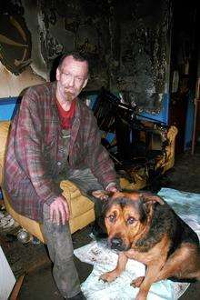 Steve Stubbs with his dog Joe in his burnt out lounge in Station Road, Whitstable