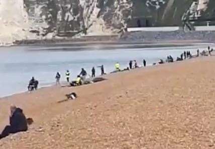 People can be seen fishing on the beach in Dover this morning