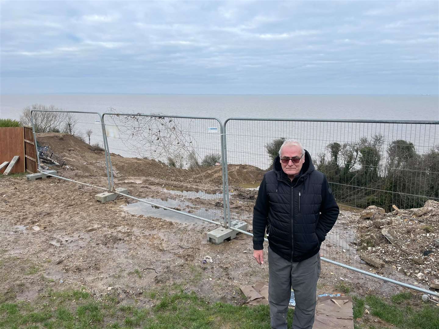 Ed Cane standing in his back garden in Third Avenue, Eastchurch, which is falling off the cliff edge