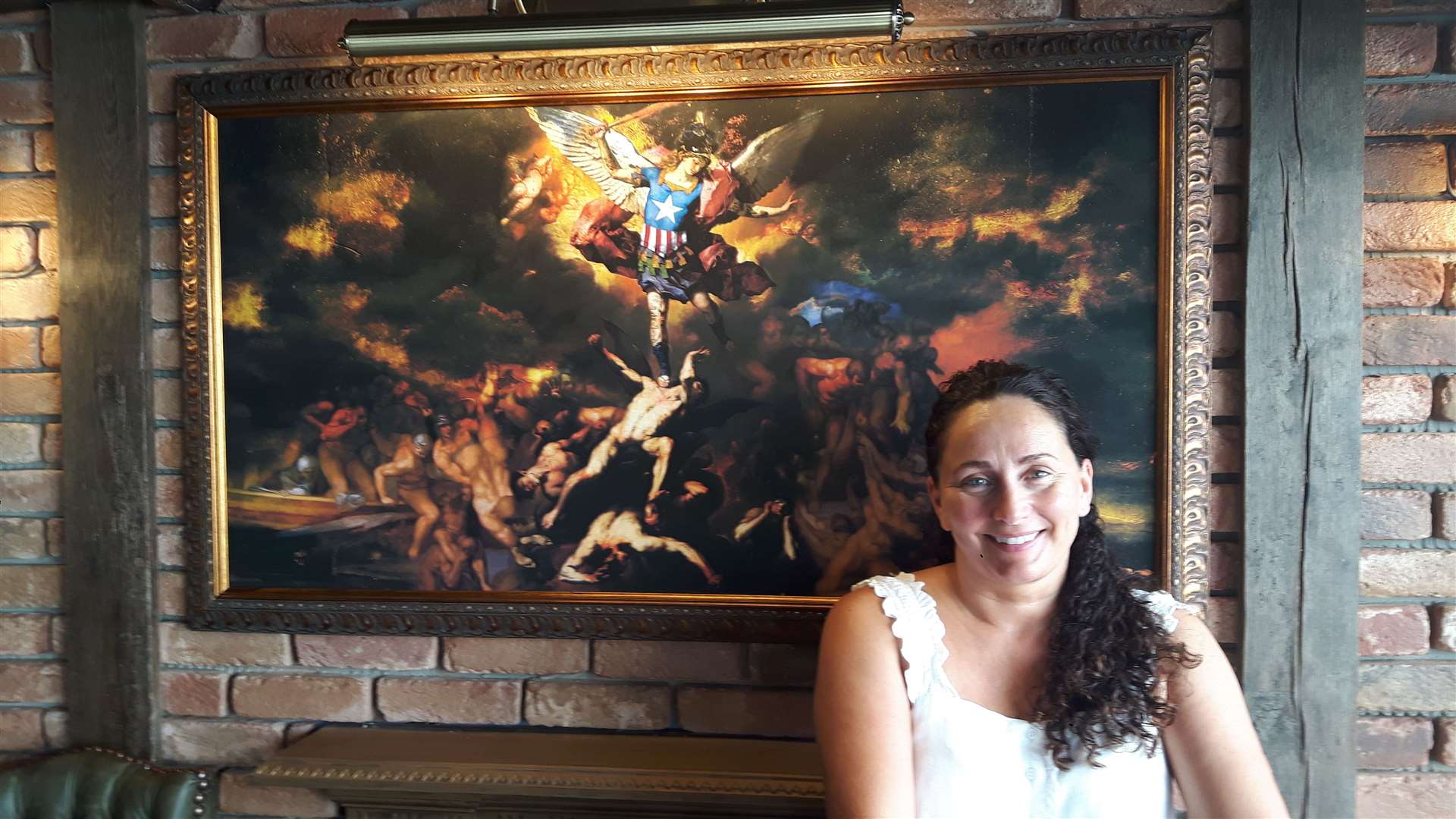 Landlady Sarah O'Quigley in front of one of the paintings by Slasky in the bar