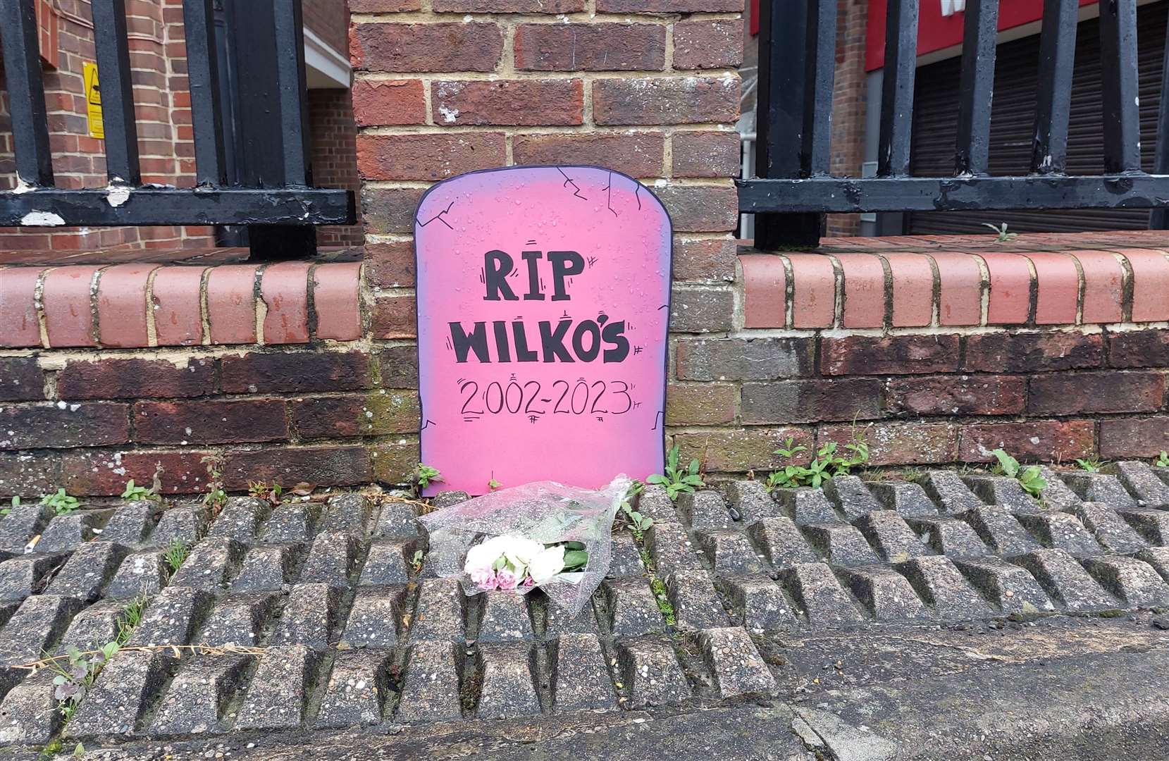 A handmade headstone and a single bunch of flowers have been left in the taxi rank in Park Street in tribute to one Wilko shop
