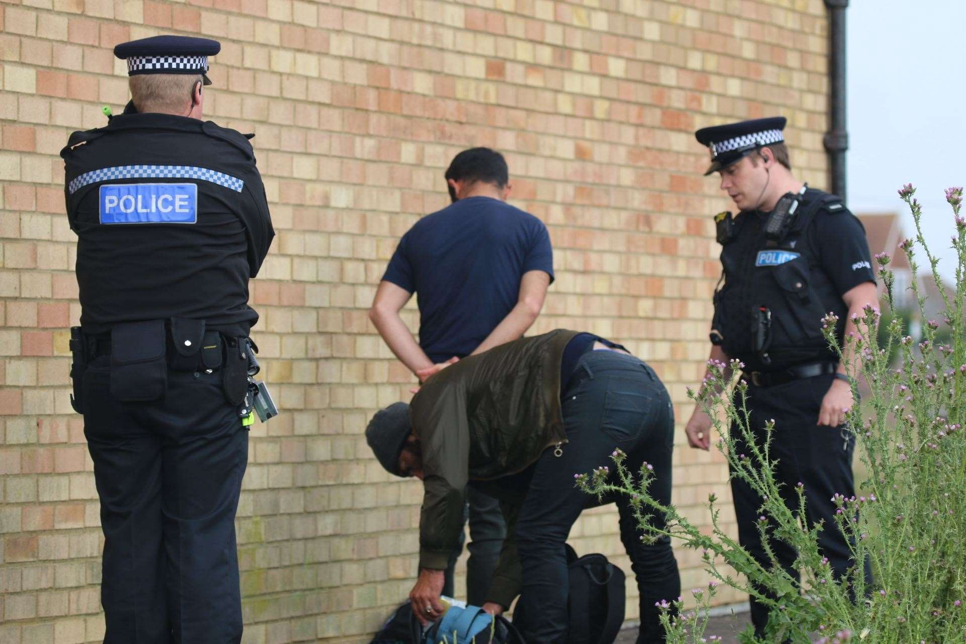 Police speak to two men after being called to the migrant landing. Picture: Susan Pilcher